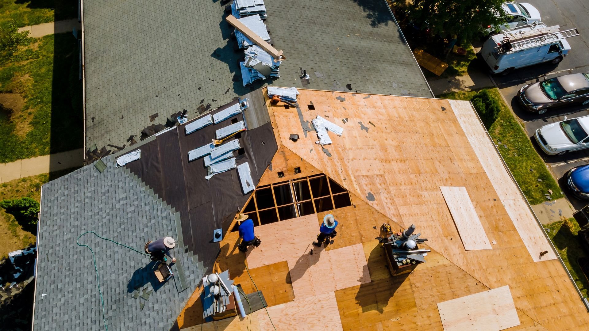 Aerial view of roofers working on a residential roof replacement project